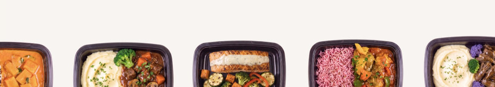 Row of gluten-free airline meal trays with beef stew, salmon, rice and a bread roll box, produced in a dedicated gluten-free kitchen
